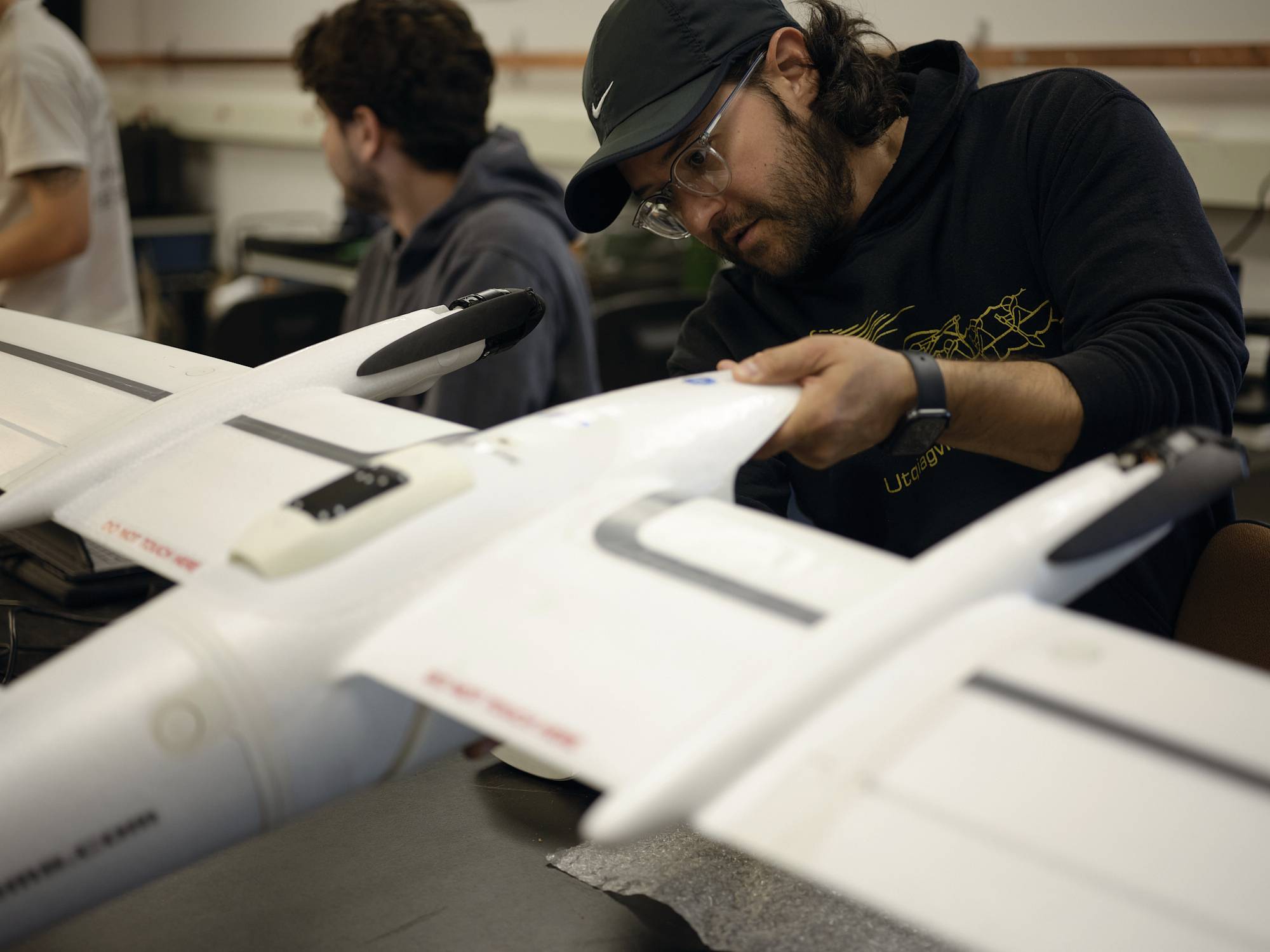 Sergio Vargas in a lab space putting together a ffixed wing drone